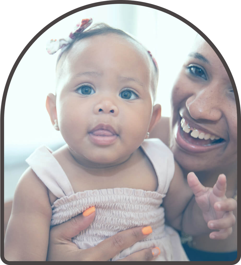 mother holding a baby smiling