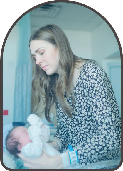 mother lifting a newborn in a hospital