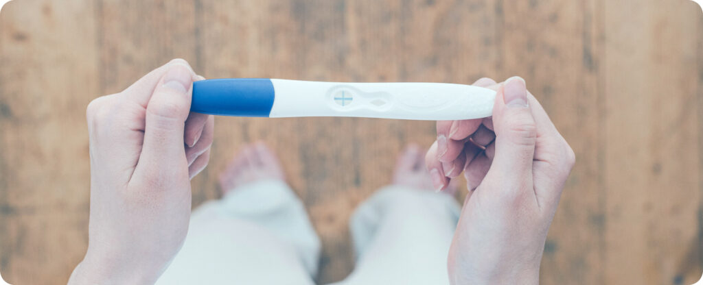 woman looking at a pregnancy test