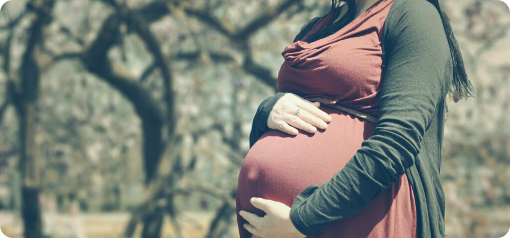 mothers hands on her pregnant belly