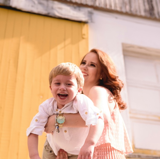 mother holding a laughing toddler